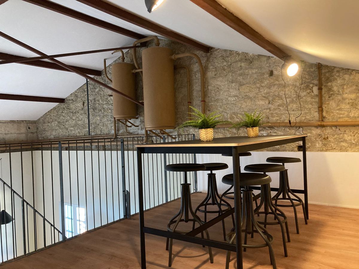 Mezzanine contemporaine, structure métallique et pierre apparente, bureaux en partie basse